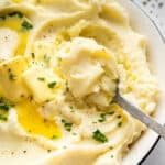 Spoon in bowl of creamy Instant Pot mashed potatoes.
