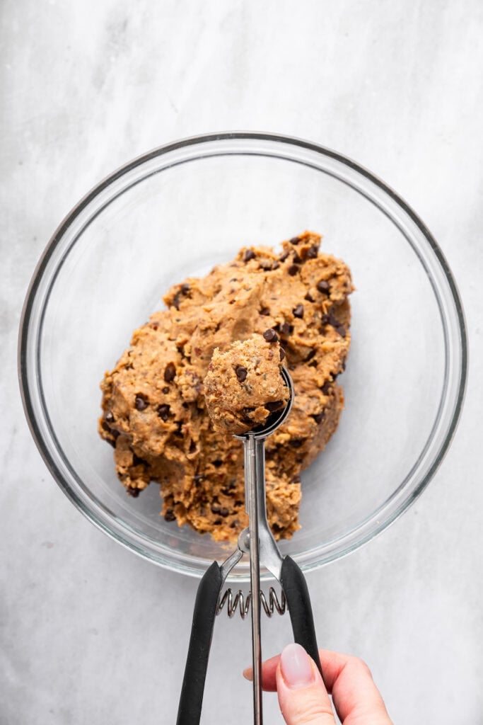 Scooping peanut butter protein ball with cookie dough scoop.