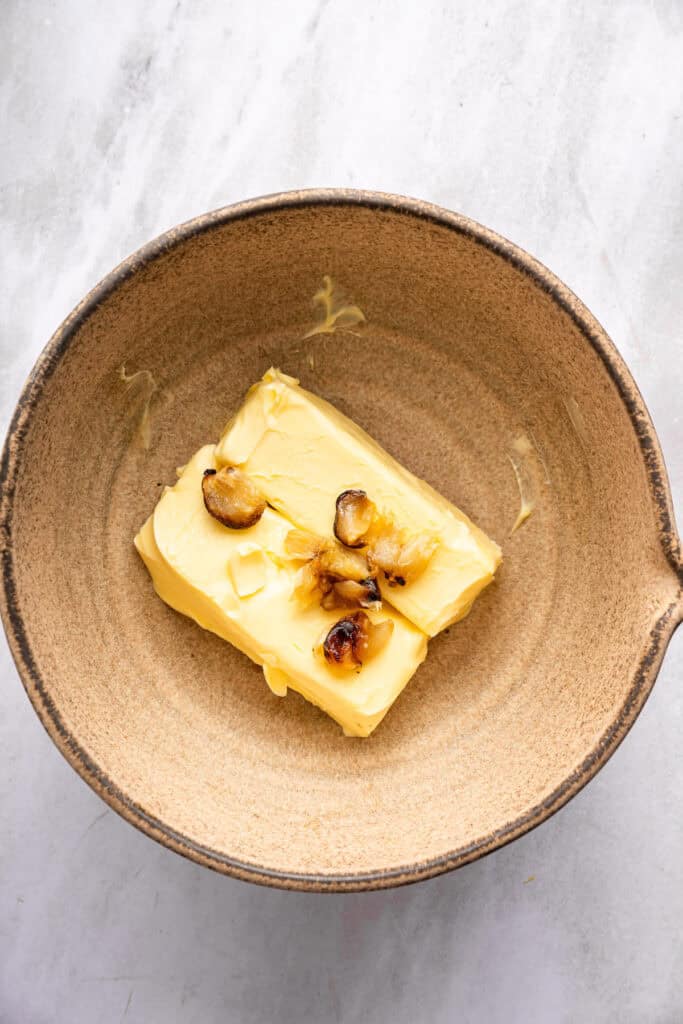 This roasted garlic butter recipe is one of the easiest ways to make just about anything taste even better. You only need 2 ingredients! Butter and roasted garlic in mixing bowl.