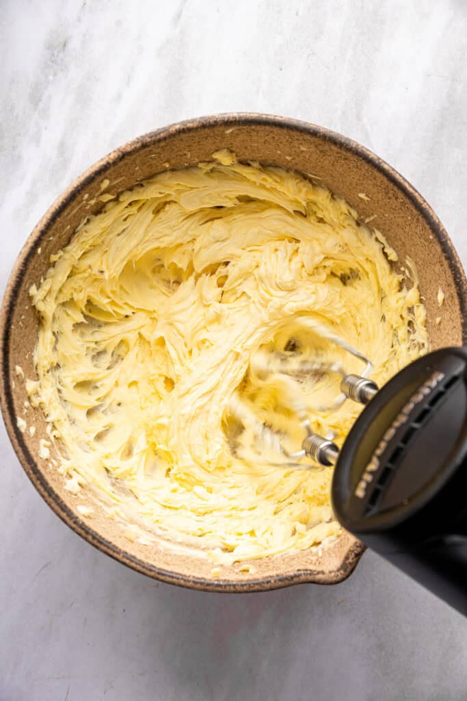 This roasted garlic butter recipe is one of the easiest ways to make just about anything taste even better. You only need 2 ingredients! Hand mixer beating garlic butter in bowl.