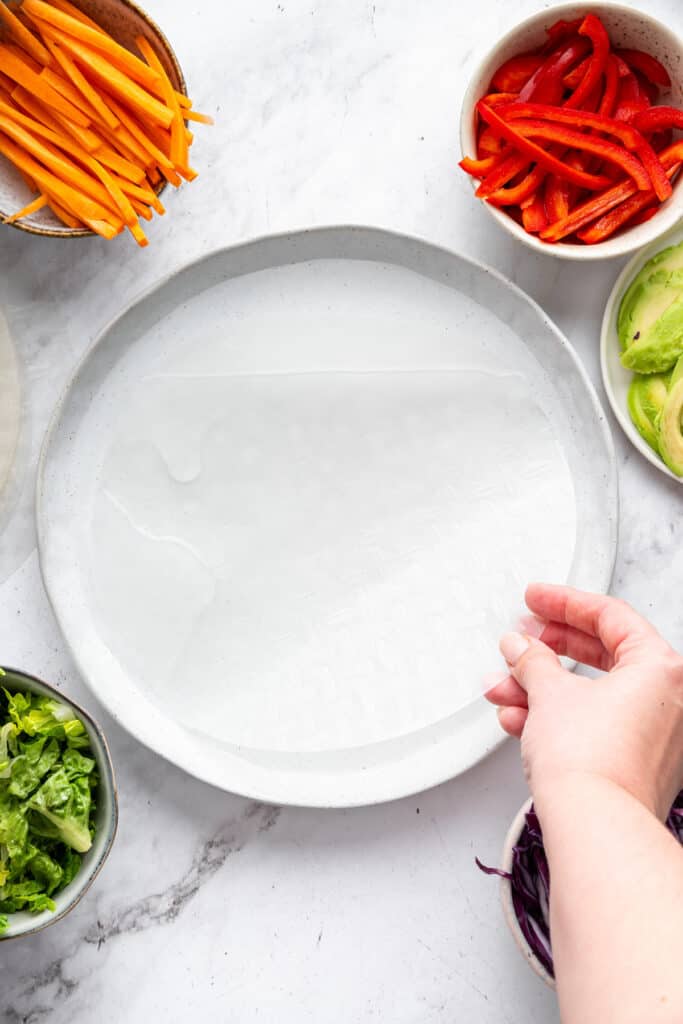 On warm days, this summer rolls recipe is a must. Crisp veggies and avocado are wrapped in rice paper for a refreshing, no-cook meal. Dipping a rice paper wrap in warm water.