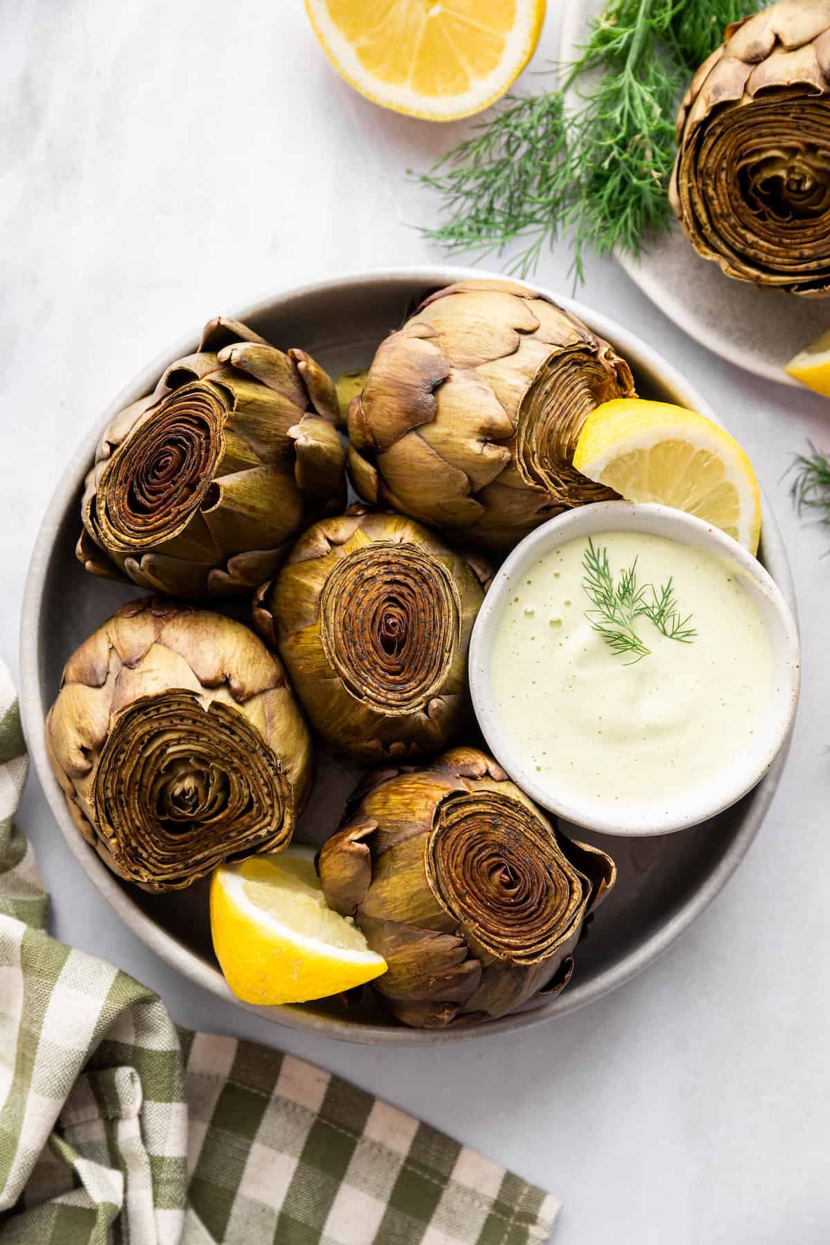 A plate for of Instant Pot artichokes with lemon dill sauce.
