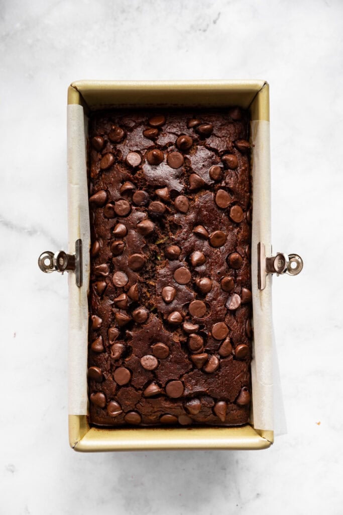 This vegan chocolate chip zucchini bread is incredibly tender, and the rich, earthy chocolate-zucchini combo is to die for. Chocolate zucchini bread cooling in a loaf pan.