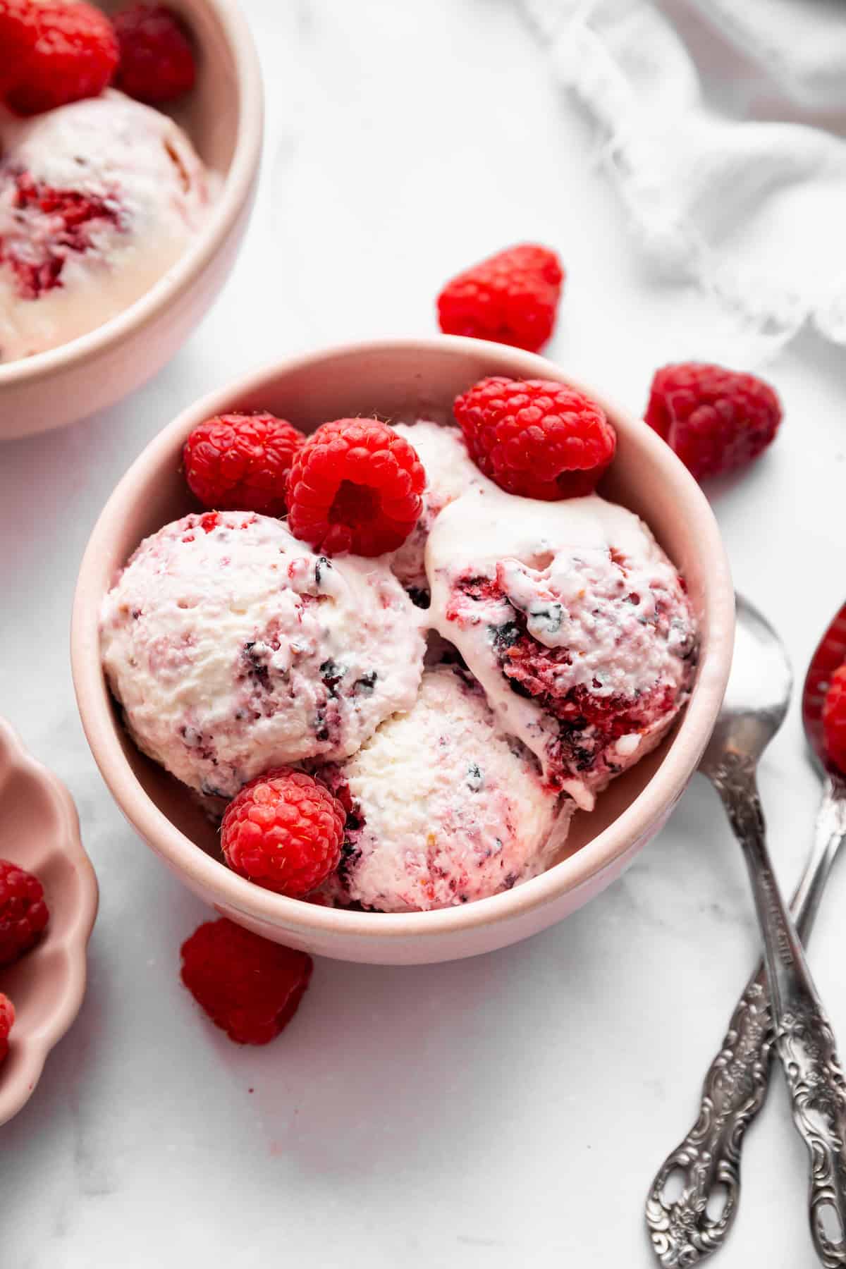 This Greek yogurt ice cream is smooth, creamy, packed with protein, and lightly sweetened with honey and a colorful swirl of fresh berries. Overhead image of a bowl of Greek yogurt ice cream with berries.