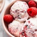 Close-up image of a bowl of Greek yogurt ice cream with berries.