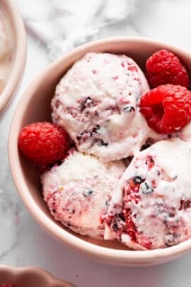 Close-up image of a bowl of Greek yogurt ice cream with berries.