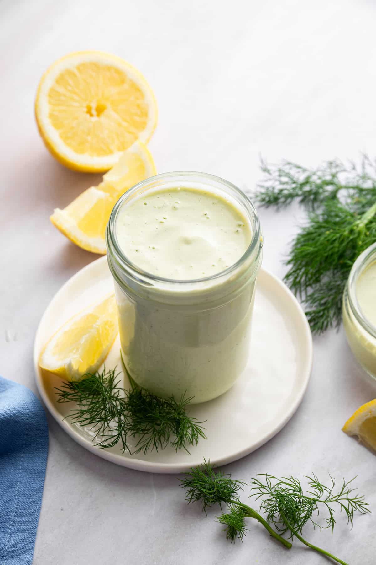 A jar of creamy lemon dill sauce on a plate.
