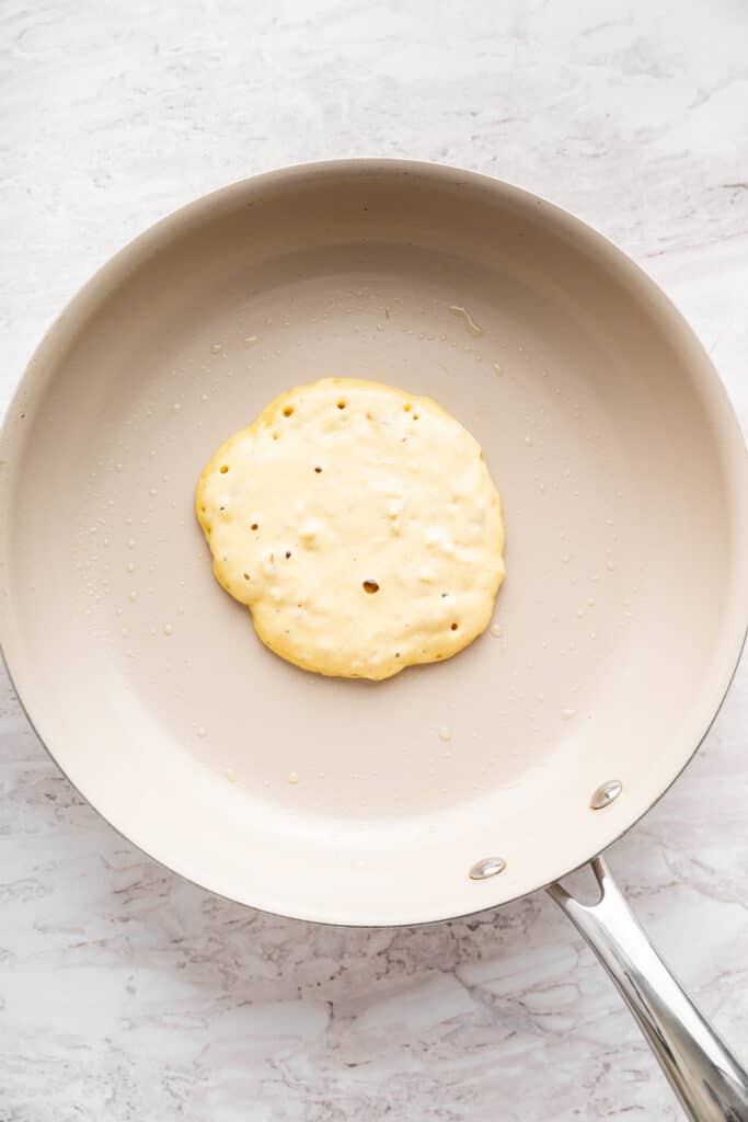 These fluffy apple cider pancakes aren't holding back on apple flavor. The apple cider really does the trick. And that hint of cinnamon? Yes! Bubbles forming on a pancake as it cooks.