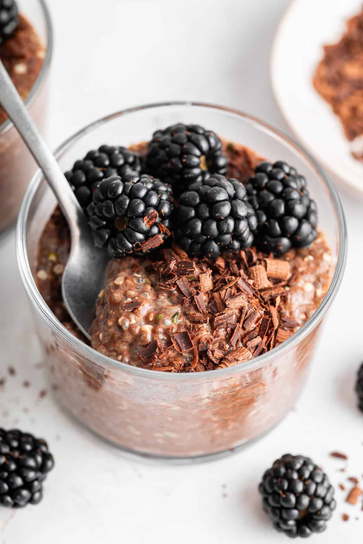 This creamy 5-ingredient chocolate chia pudding packs a powerful punch of protein and just-sweet-enough chocolate pizzaz. And it's so easy! A spoon diving into creamy chocolate chia pudding in a jar.