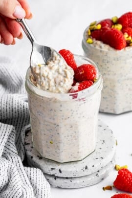 A spoon scooping into a jar of high protein overnight oats.