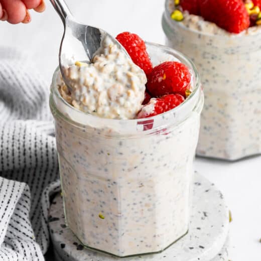 A spoon scooping into a jar of high protein overnight oats.